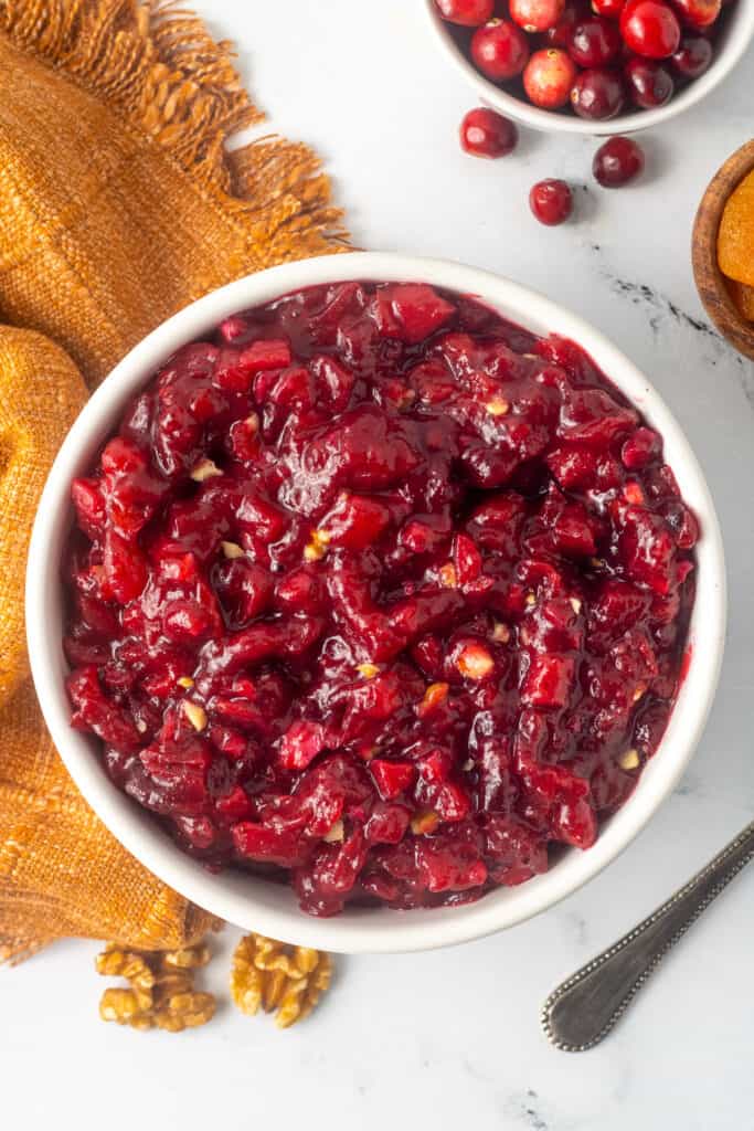 A top down shot of cranberry apricot chutney next to a gold kitchen cloth.