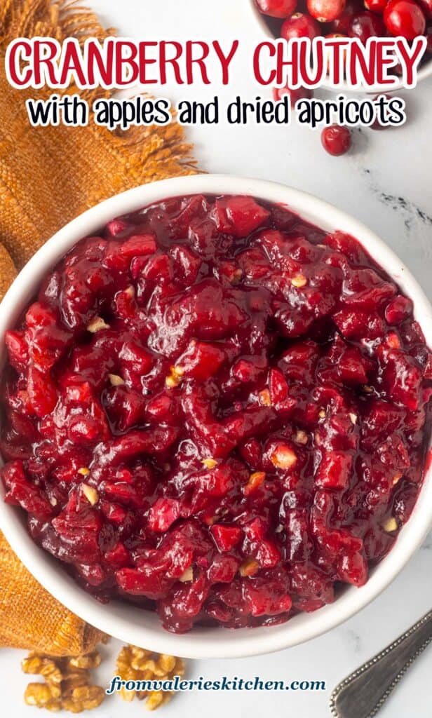 A top down shot of cranberry apricot chutney next to a gold kitchen cloth with text.