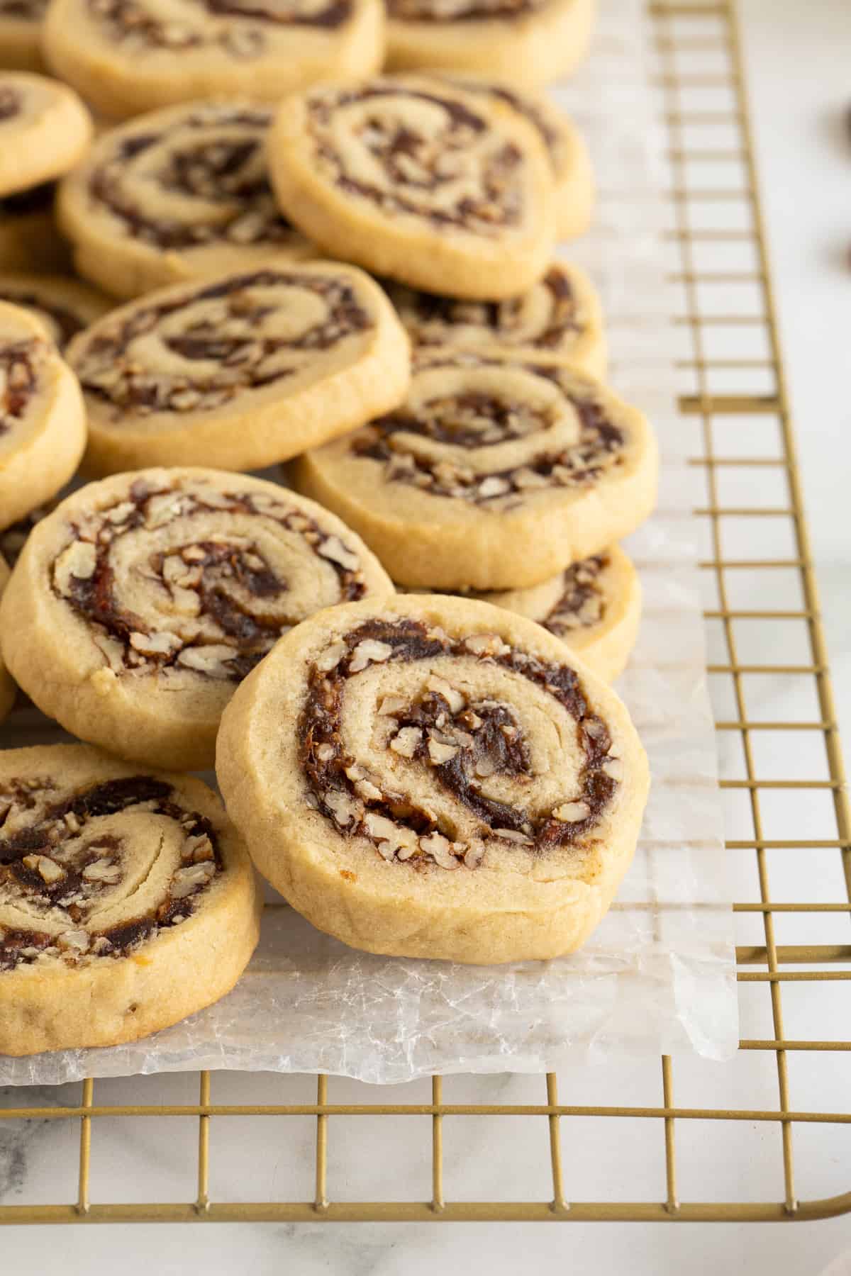 Date pinwheel cookies piled on a wire rack.