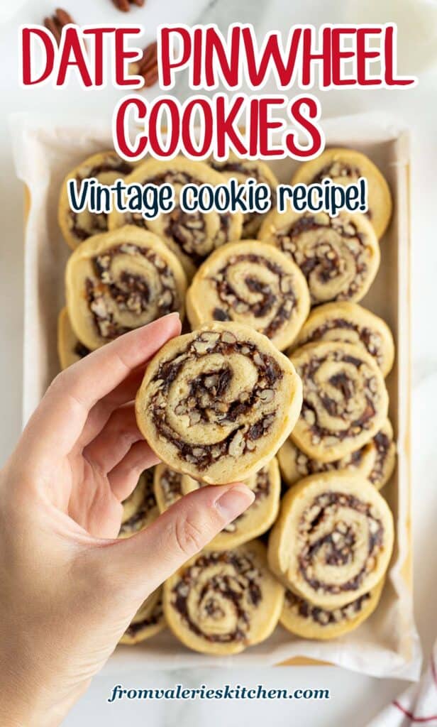 A hand holding a date pinwheel cookie over a platter of cookies with text.