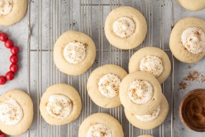 Eggnog thumbprint cookies on a wire rack.