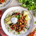 A top down shot of a ground turkey taco bowl topped with avocado and sour cream.