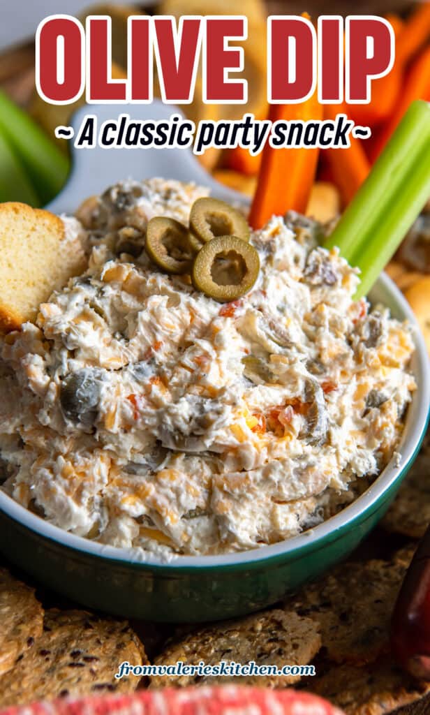 A close up of a carrot and celery stick pressed into a bowl of olive dip with text.