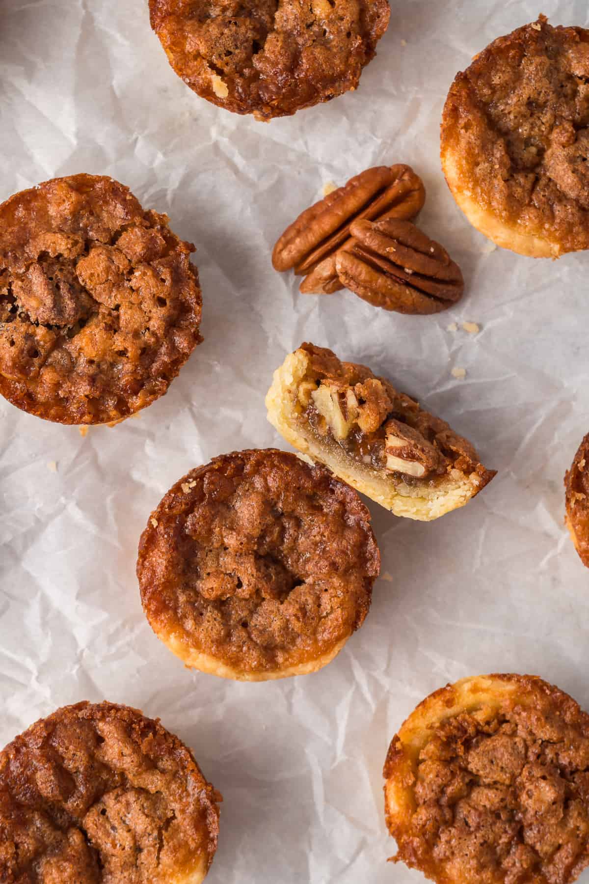 A top down shot of pecan tarts on parchment paper.