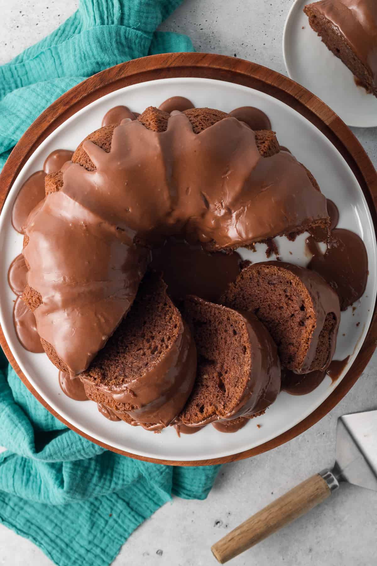 A top down shot of a sliced black russian bundt cake on a white platter.