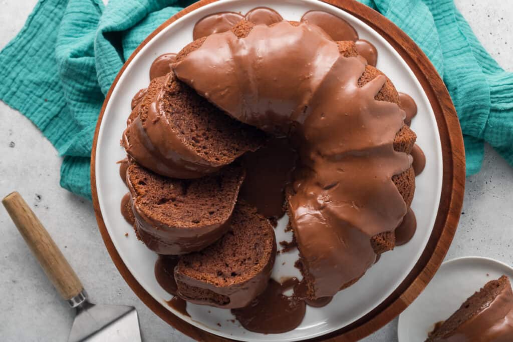 A top down shot of a sliced black russian bundt cake on a white platter.