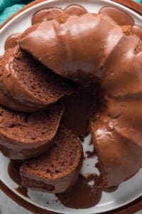 A top down shot of a sliced black russian bundt cake on a white platter.