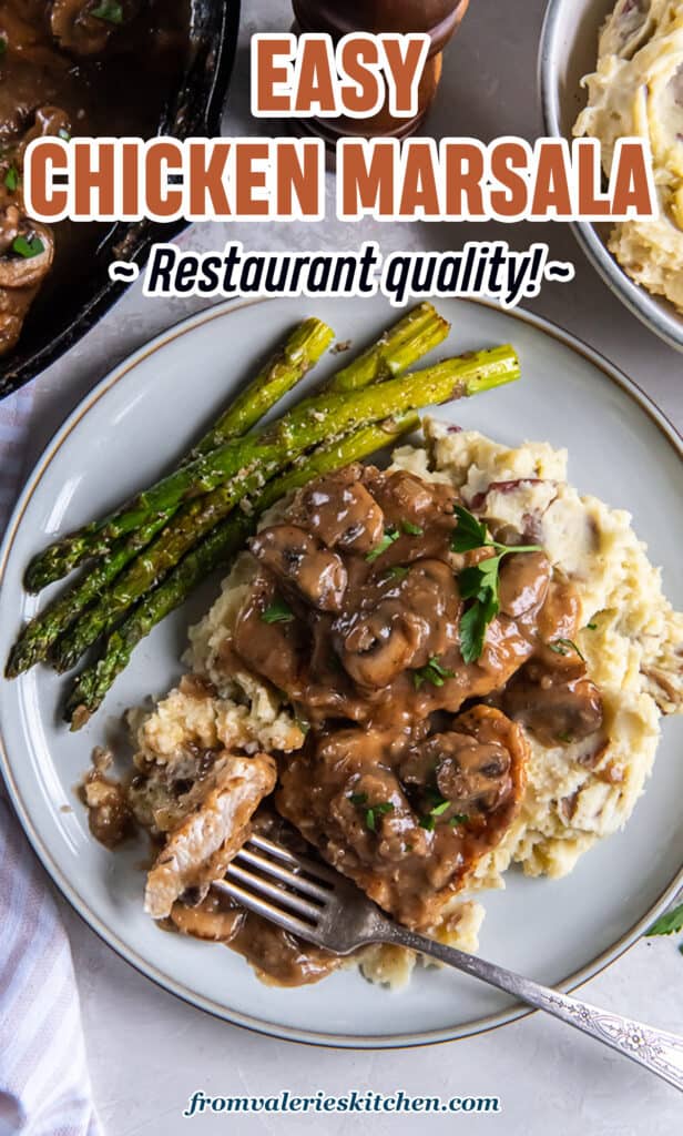 Chicken marsala on a white plate with mashed potatoes and asparagus.