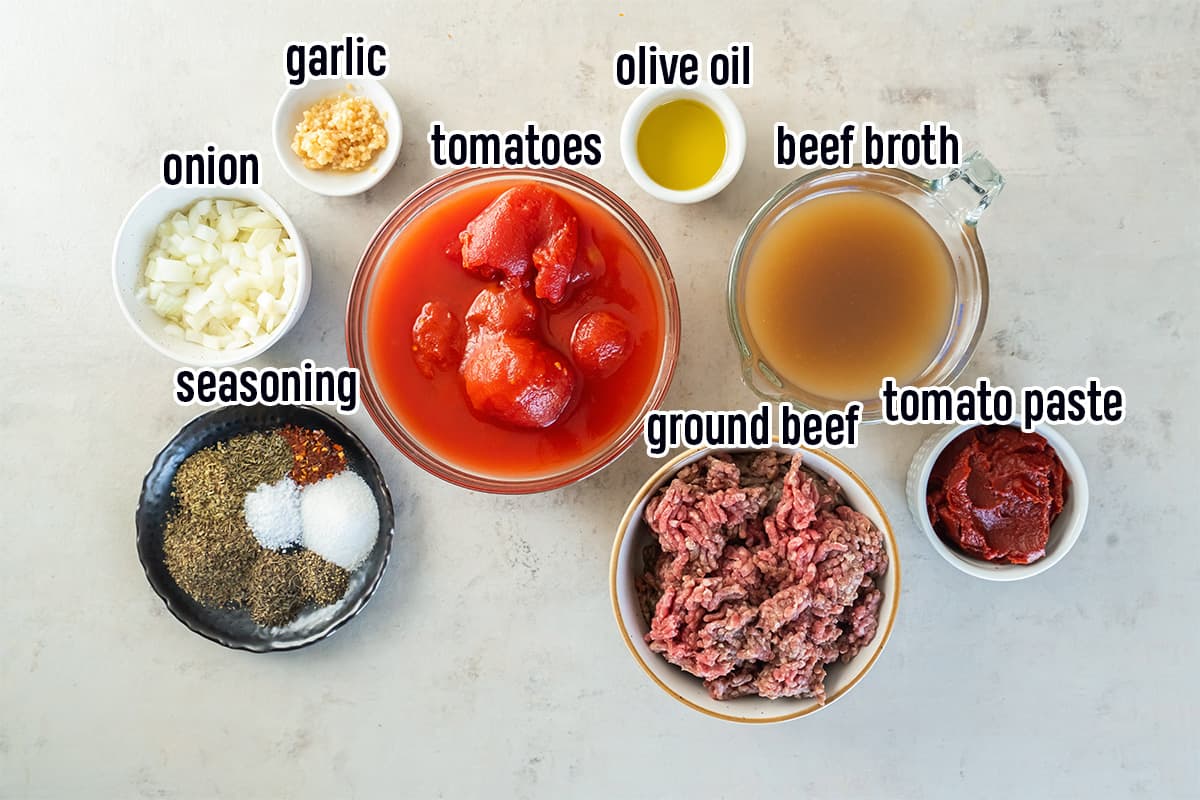 Tomatoes, ground beef, garlic and other ingredients for spaghetti sauce in bowls with text.