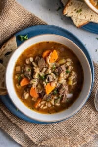 A top down shot of a bowl of beef barley soup.