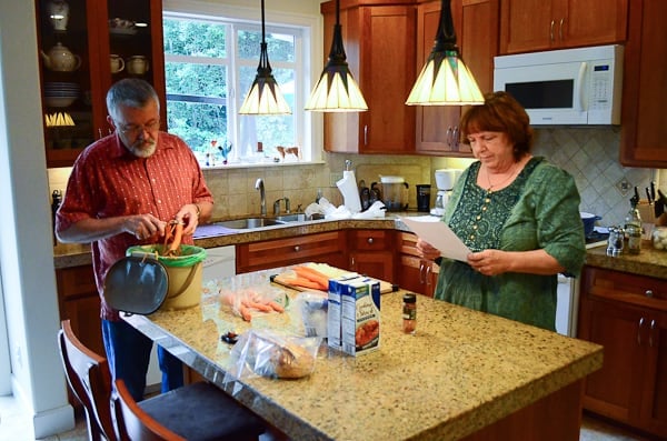 A man and woman standing at a kitchen counter.