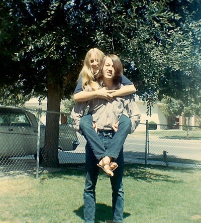 A young man holding a young woman on his back.