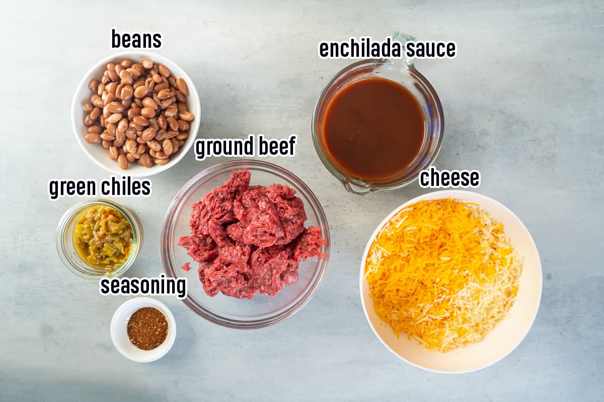 Raw ground beef, pinto beans, enchilada sauce and other ingredients with text.