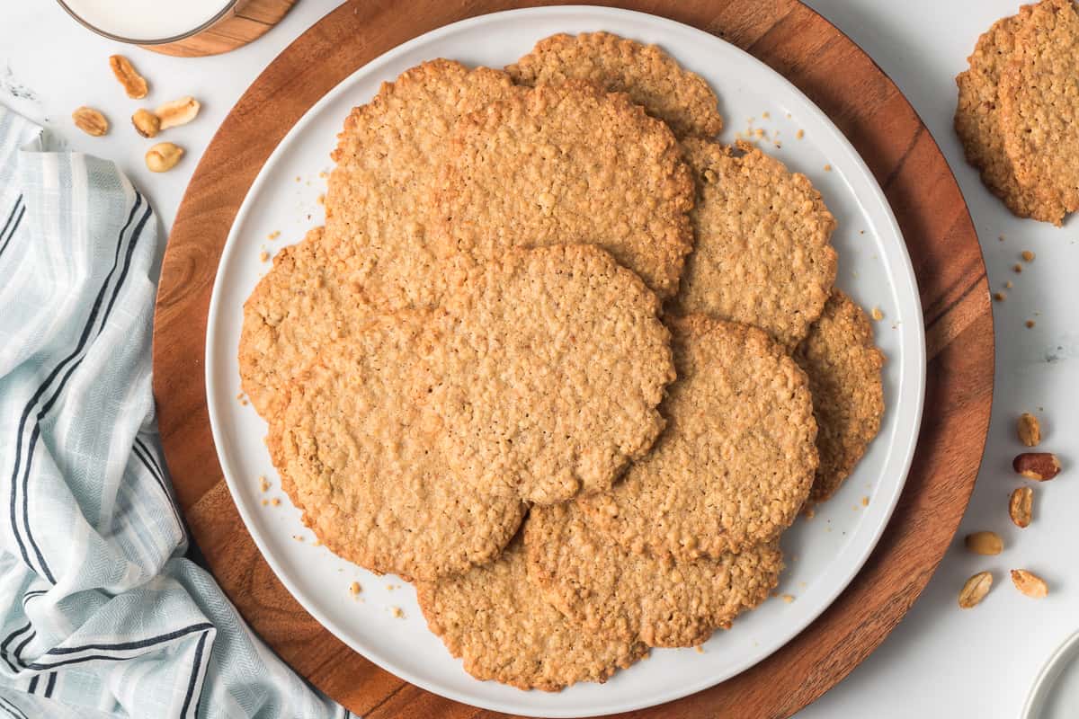 A pile of thin crispy peanut cookies on a platter.