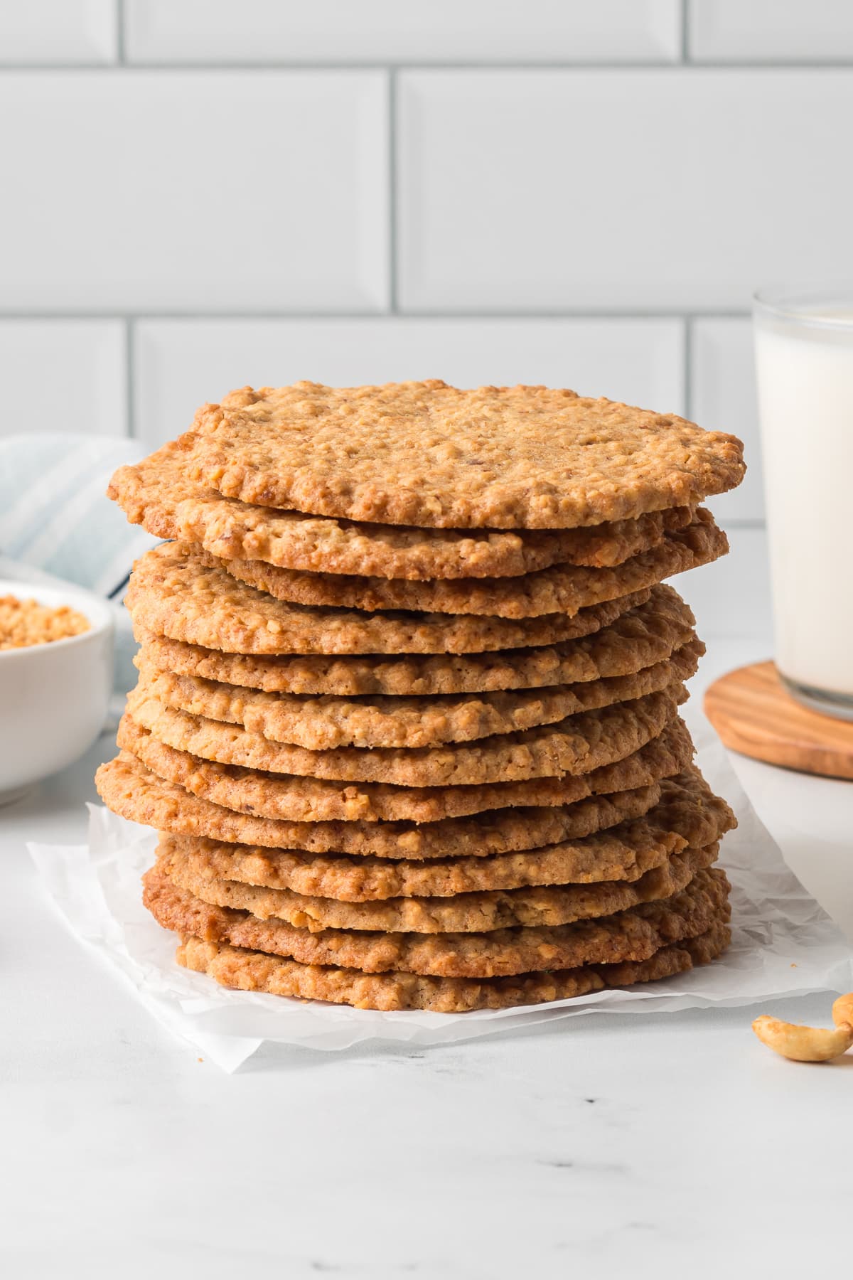 A stack of thin crispy peanut cookies on a kitchen counter.