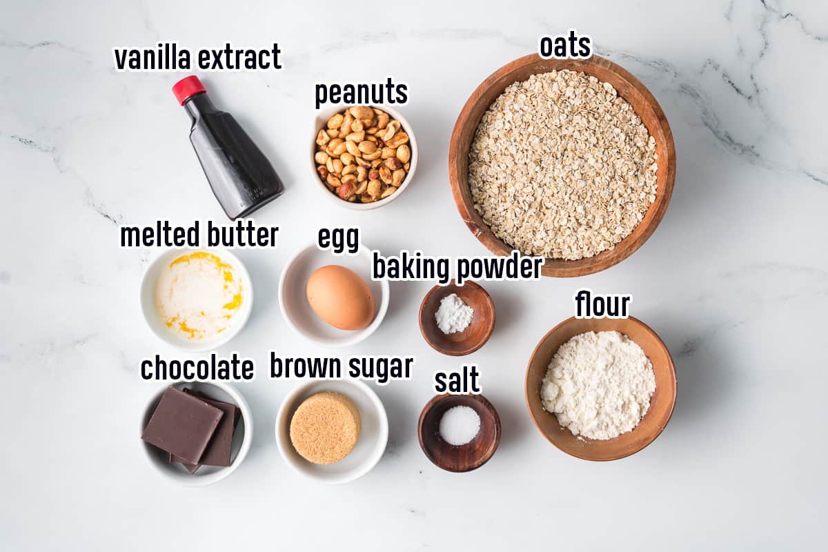 Oats, flour, peanuts and other ingredients in small bowls with text.