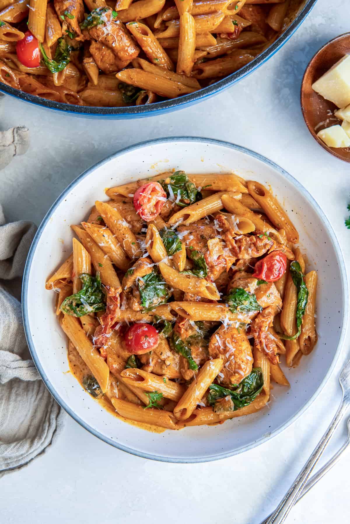 Tuscan chicken pasta in a white bowl.