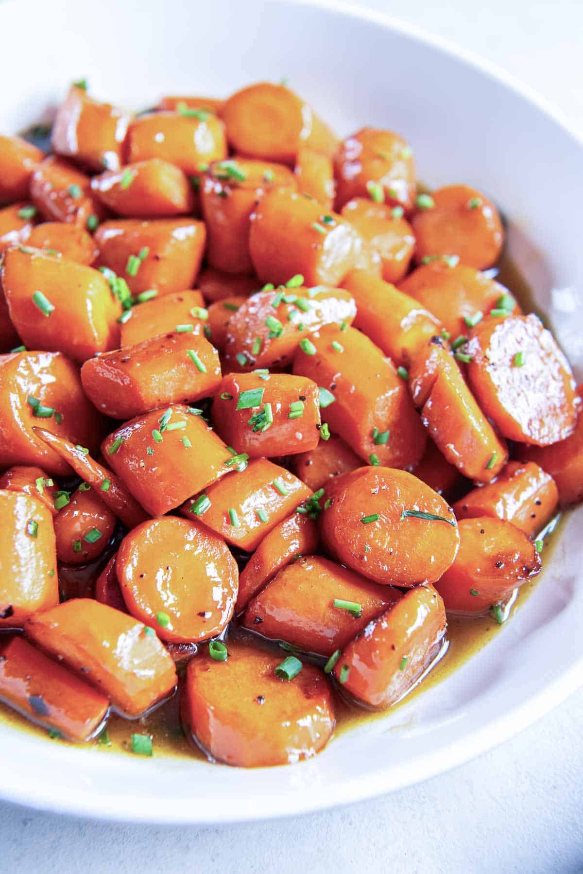 Bourbon glazed carrots in a white serving bowl.