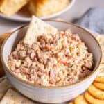 A saltine cracker pressed into a bowl of ham salad.