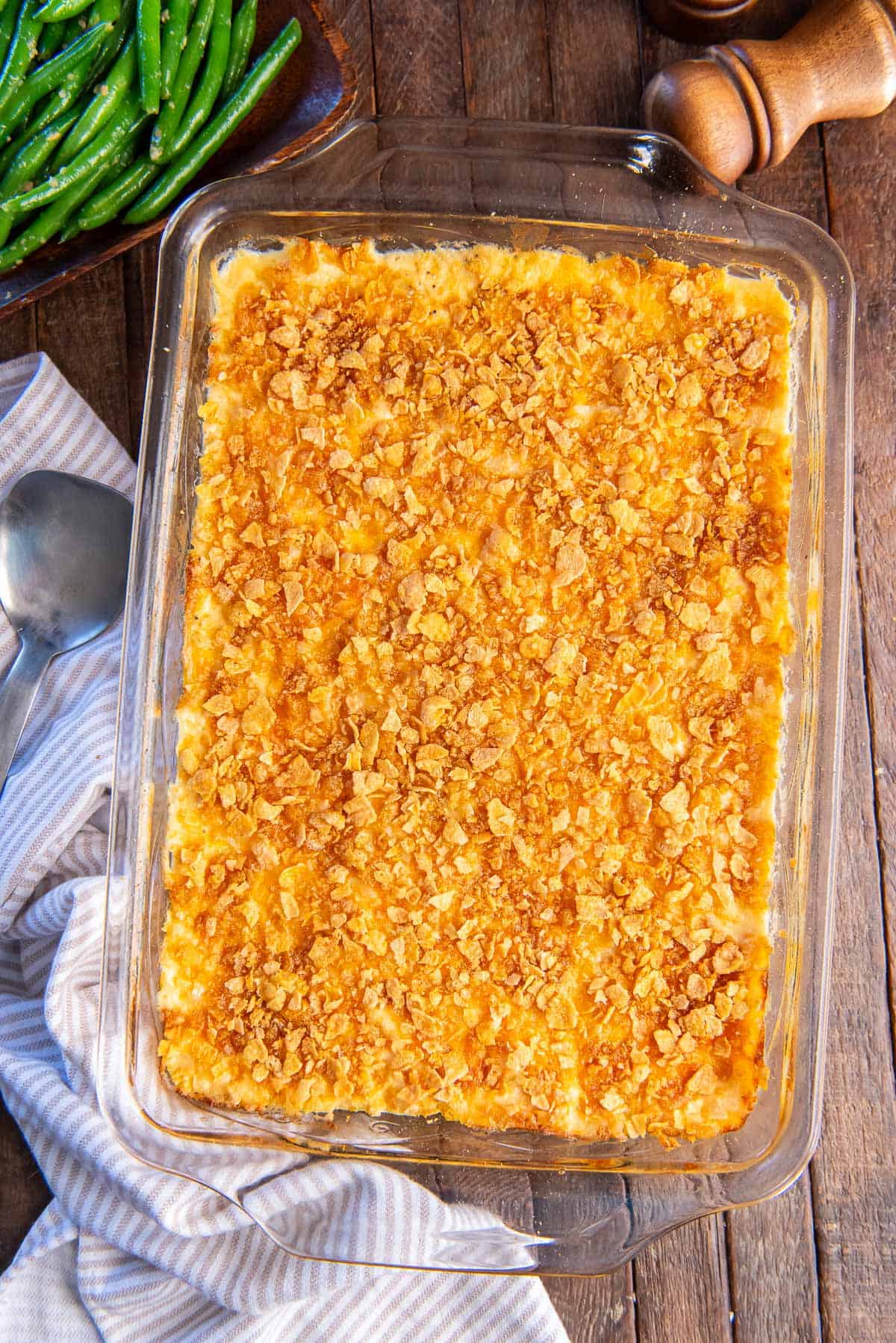 Hash brown casserole topped with corn flakes in a baking dish.