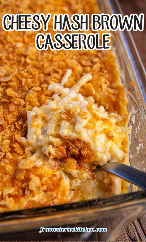 A spoon resting in cheesy hash brown casserole in a baking dish with text.