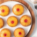 Mini pineapple upside down cakes on a white plate.