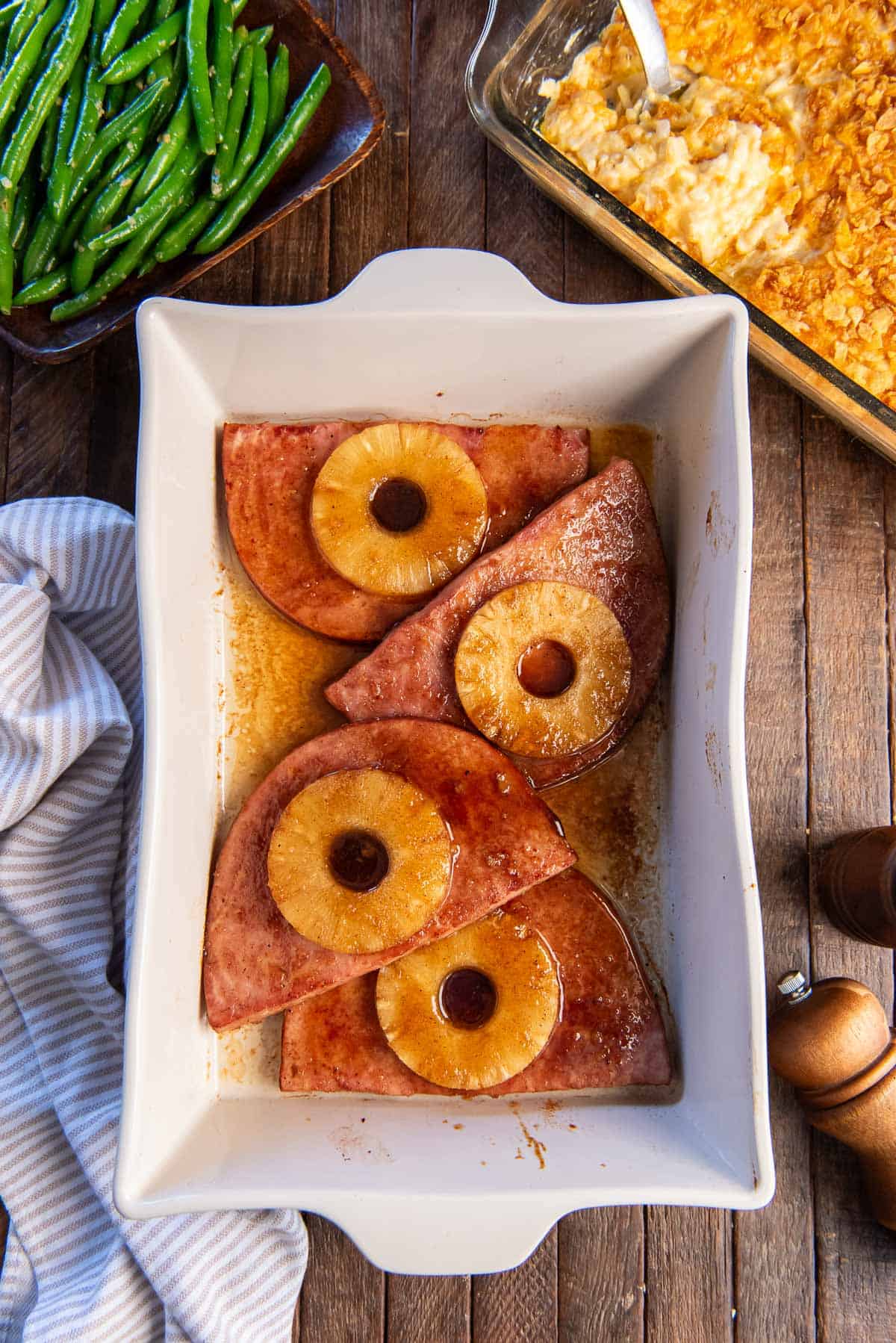 Pineapple ham steaks in a white baking dish.