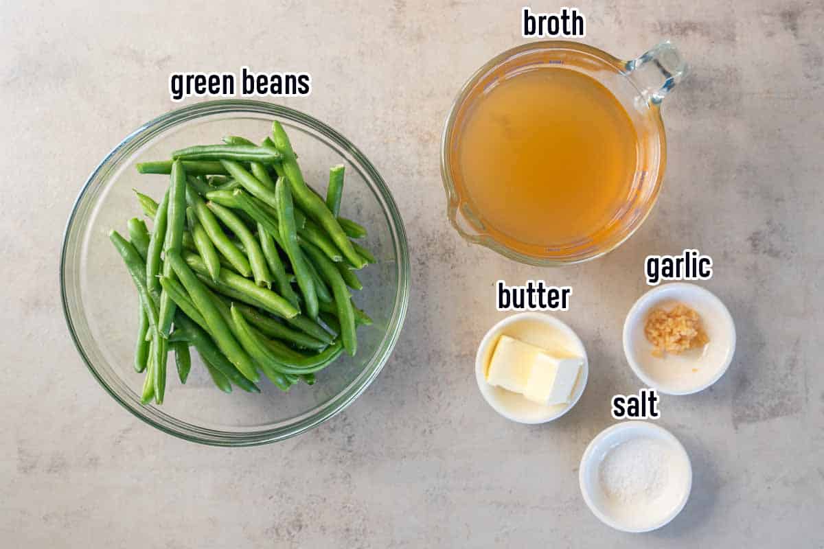 Green beans, chicken broth, butter, garlic, and salt in bowls with text.