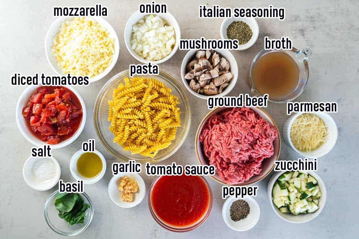 Dry pasta, ground beef, cheese, diced tomatoes and other ingredients in bowls with text.