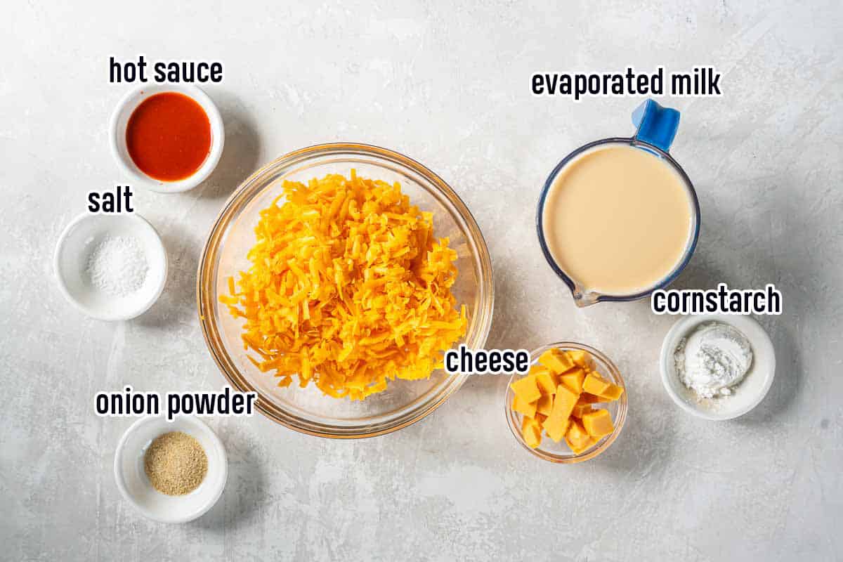 Shredded cheddar cheese, cubed Velveeta cheese, and other ingredients with text.