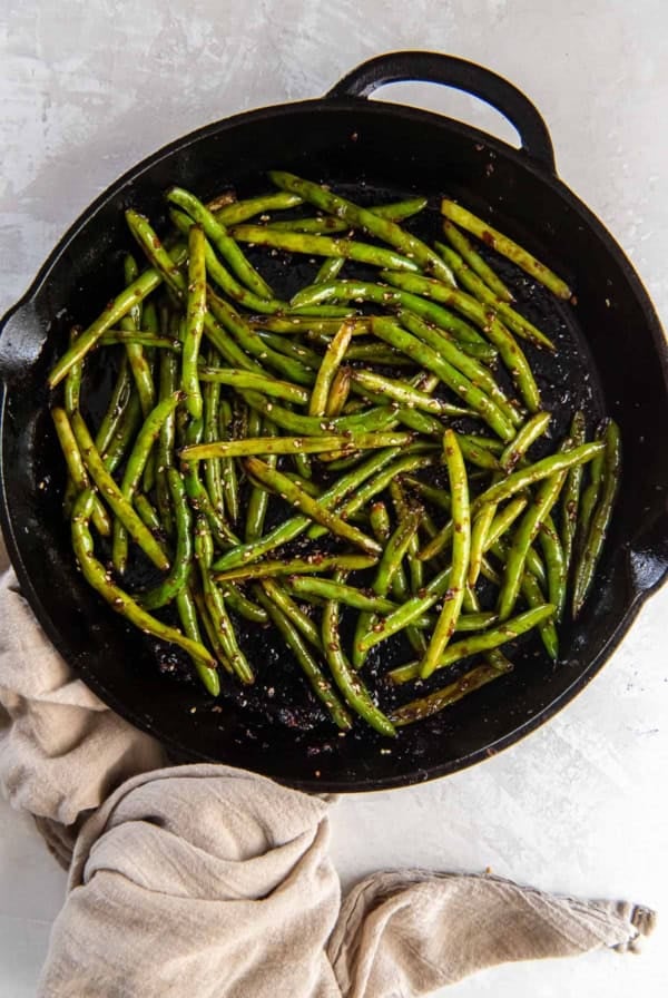 Stir fried Asian green beans in a cast iron skillet.