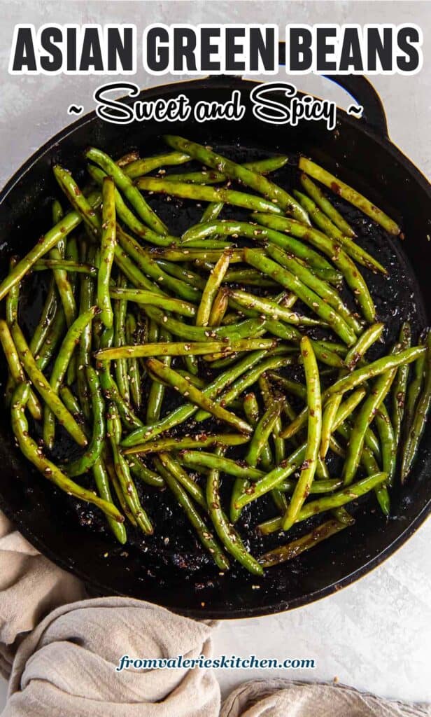 Stir fried Asian green beans in a cast iron skillet with text.