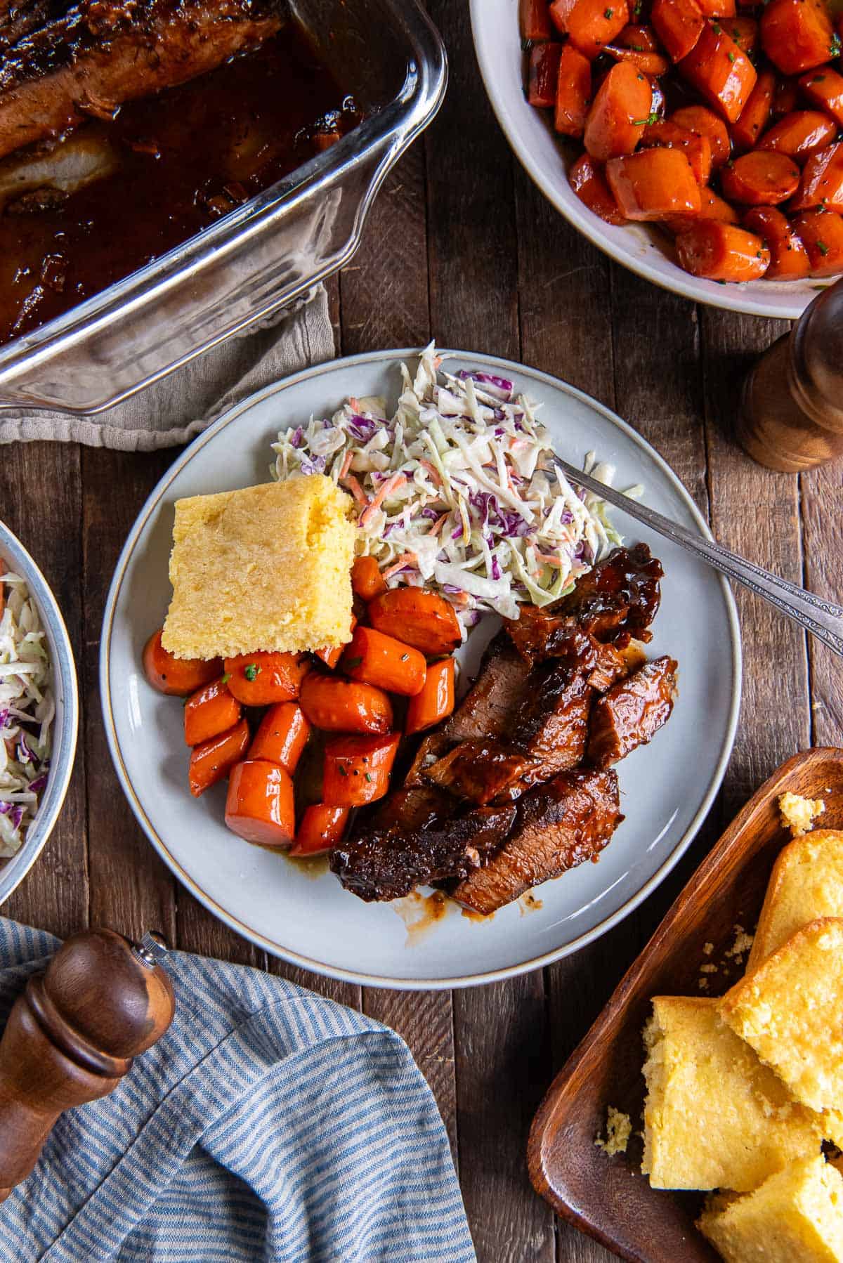 Brisket on a dinner plate surrounded by side dishes.