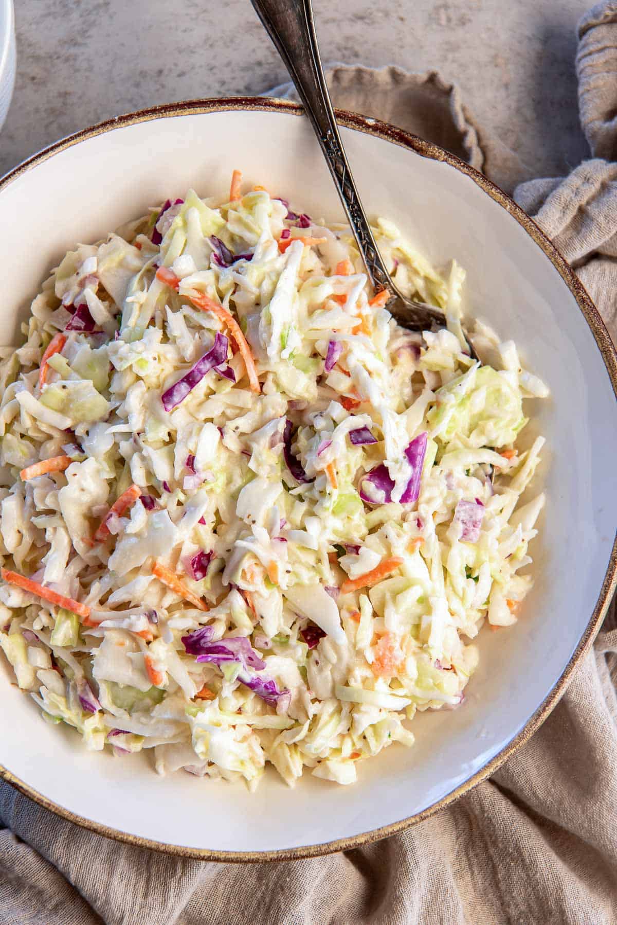 Coleslaw in a bowl with a spoon.