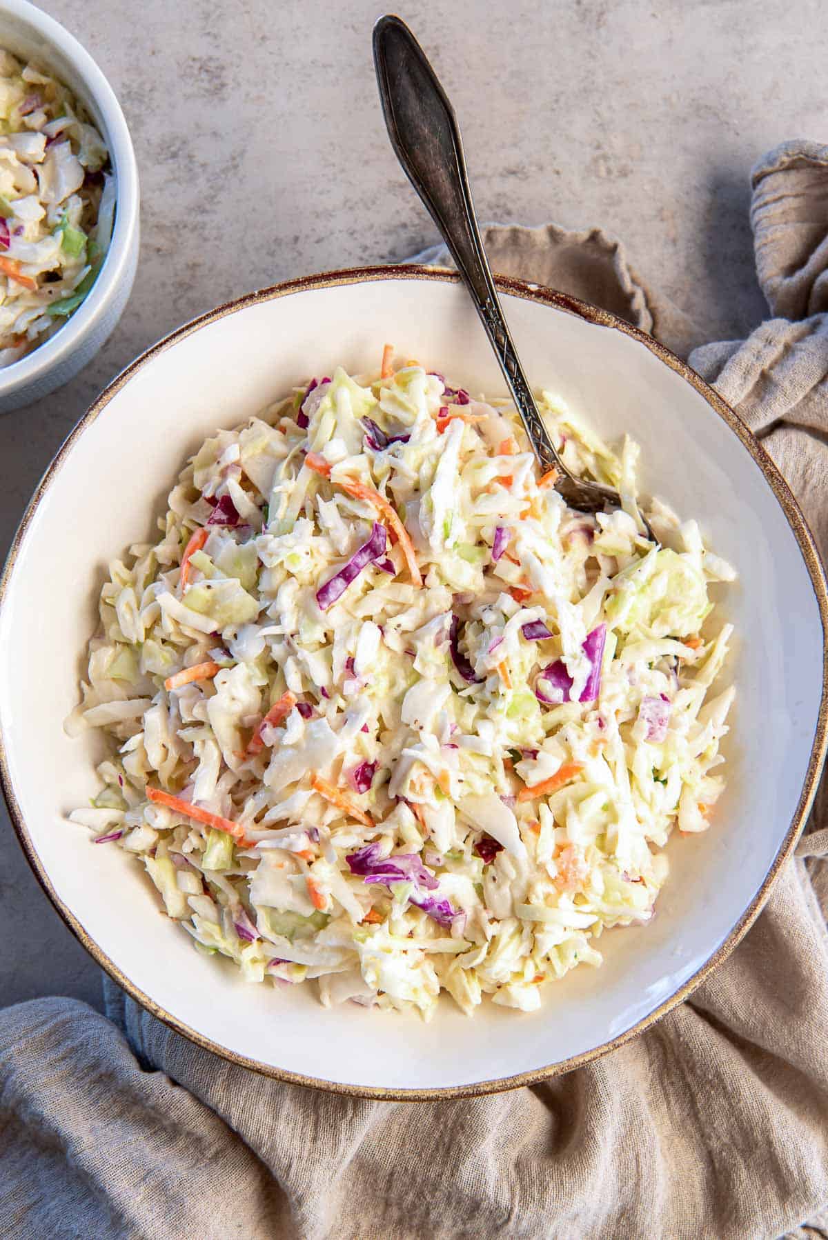 Coleslaw in a bowl with a spoon.