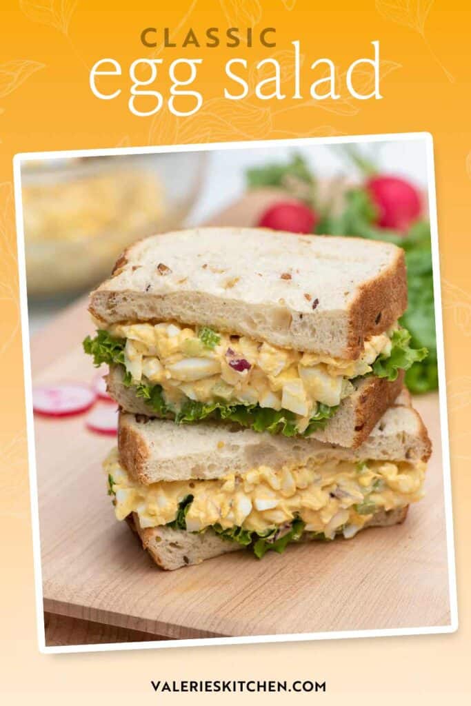 An egg salad sandwich sliced in half and stacked on a cutting board with text overlay.