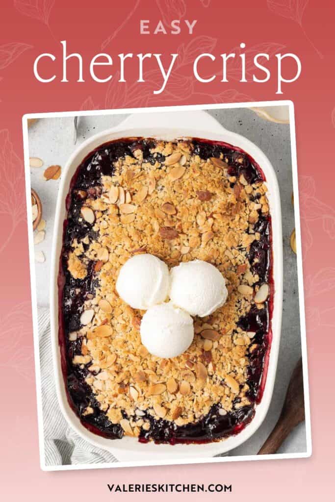 Three scoops of ice cream on top of cherry crisp in a white baking pan with text overlay.