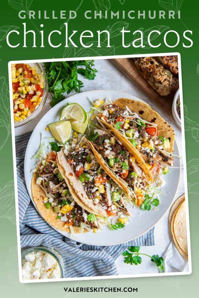Chimichurri chicken tacos with corn, tomatoes, avocado, and cabbage on a white plate with text.