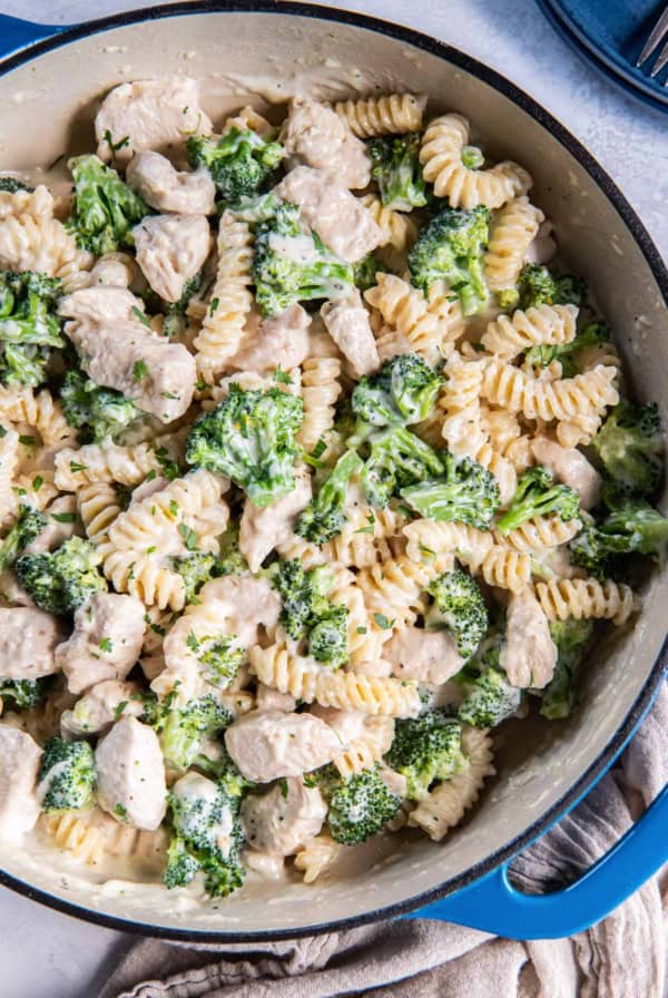 Chicken broccoli alfredo in a blue skillet.