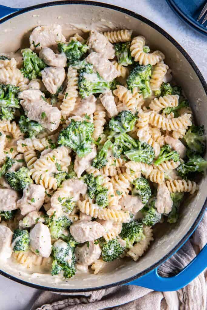 Chicken broccoli alfredo in a blue skillet.