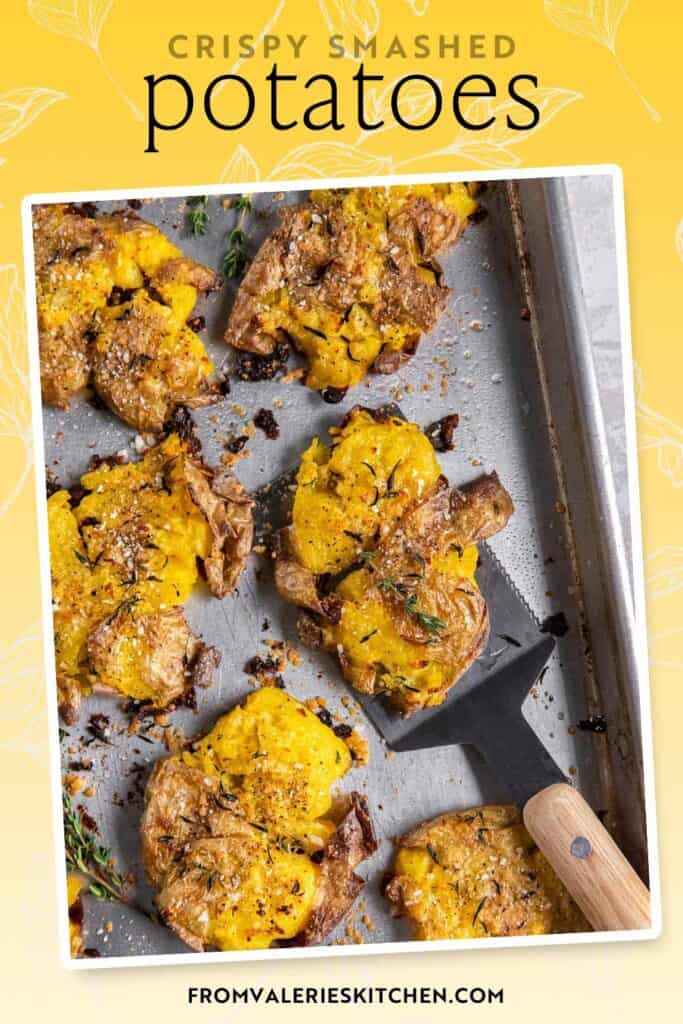 A spatula resting under a smashed potato on a baking sheet with text overlay.