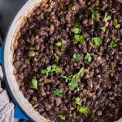 Cuban black beans in a skillet topped with cilantro.