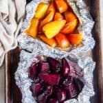 Roasted beets in foil packets on a baking sheet.
