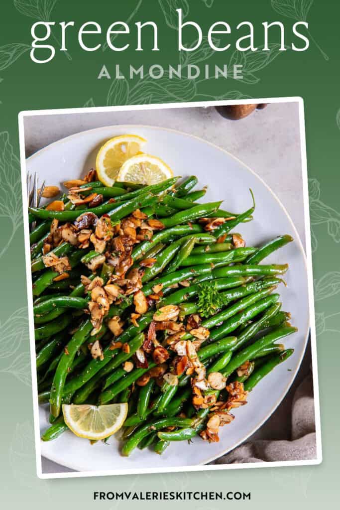Green beans almondine on a white plate with lemon slices with text overlay.