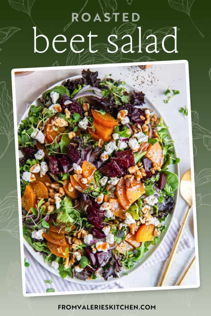 A roasted beet salad on a white platter with serving spoons lying next to it with text overlay.