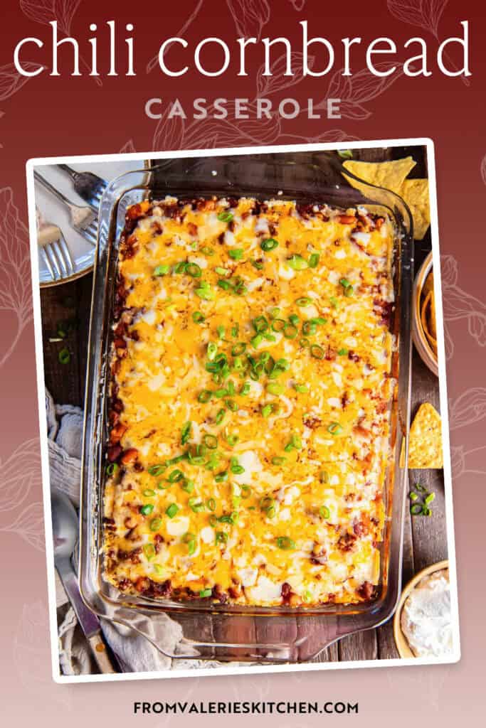 Chili cornbread casserole topped with green onions on a brown board next to a bowl of sour cream and tortilla chips with text overlay.