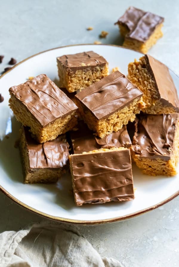 Scotcheroos stacked on a white plate.