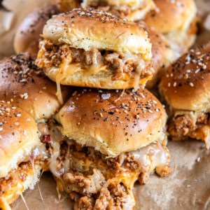 A stack of ground turkey burger sliders with melted cheese.