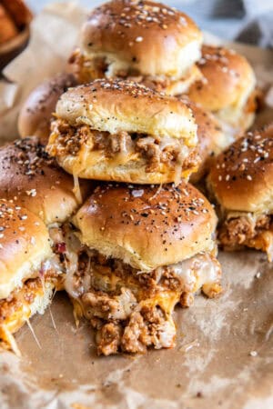 A stack of ground turkey burger sliders with melted cheese.