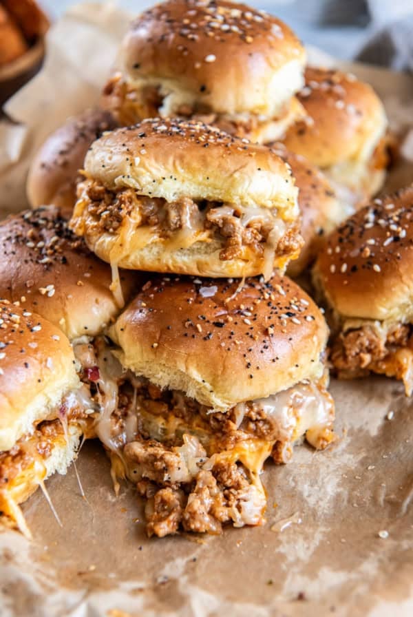 A stack of ground turkey burger sliders with melted cheese.